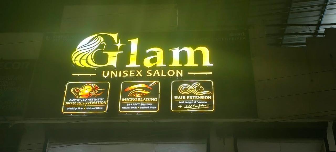 The GLAM Unisex Salon sign lit above the entrance